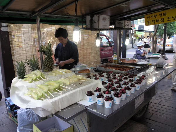 Lady prepares food at food stand on sidewalk — Stock Photo, Image