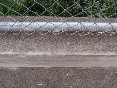 Paslı zincir bağlantı çit ve beton kaldırım onun ekli