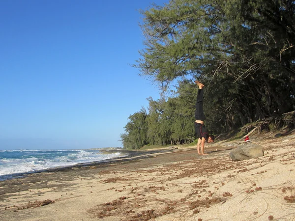 Man handstands on Lava rocks on North Shore Beach — Stock Photo, Image