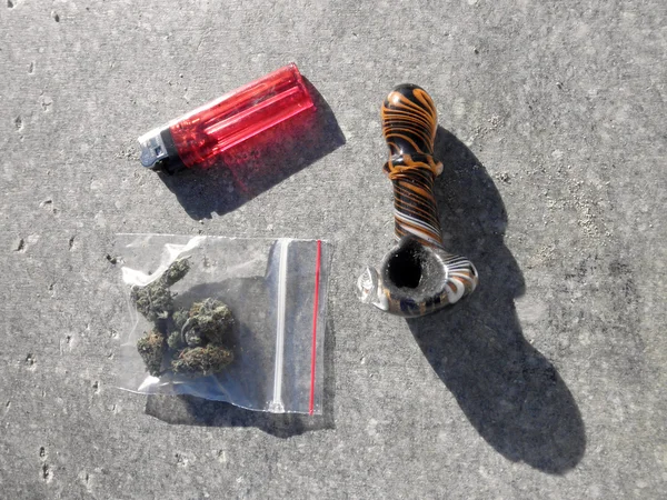 Tasche mit medizinischem Marihuana, Pfeife und Feuerzeug auf Beton — Stockfoto