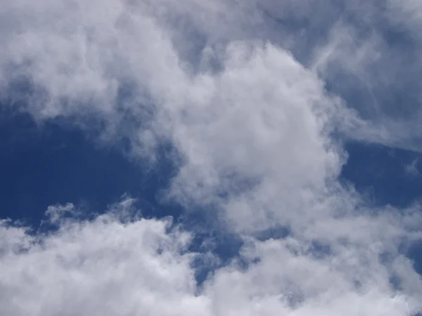 Nubes esponjosas en un cielo azul — Foto de Stock