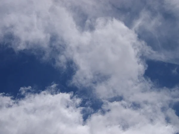 Flauschige Wolken am blauen Himmel — Stockfoto