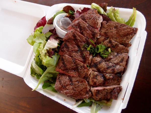 Steak mit Salat auf einem to-go Styroporteller — Stockfoto
