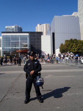 SFPD Police officer stand on street with helmet resting on hip clipart