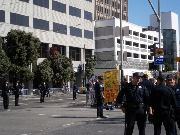 Les policiers de la SFPD se tiennent dans la rue pendant que les manifestants tiennent signe disent — Photo