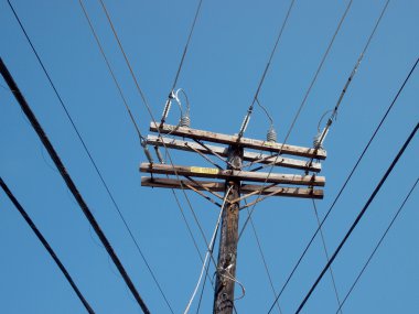 Yüksek gerilim enerji hatları ahşap elektrik direğinden kesiştiği