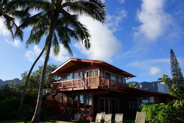 Zweistöckiges rotes Strandhaus mit hohen Kokospalmen — Stockfoto