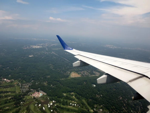 Asa do avião enquanto voa para a cidade — Fotografia de Stock