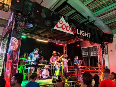 Honolulu - 6 Eylül 2019 'da Ala Moana Alışveriş Merkezi' nde Coors Light logosu olan Mai Tai Bar 'da şarkı söyleyen, müzik çalan rehber grup.