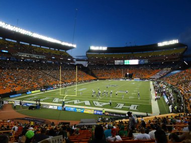Hawaii - 19 Eylül 2015: UH Football ve UC Davis oyuncuları, Honolulu 'daki Aloha Stadyumu' nda üniversite maçında seyircilerle birlikte tribünde oynamaya hazırlar., .             
