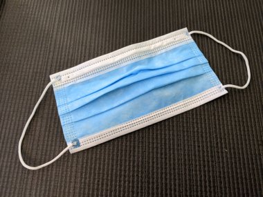 Minderde kulaklık takan Mavi Cerrahi Maske.