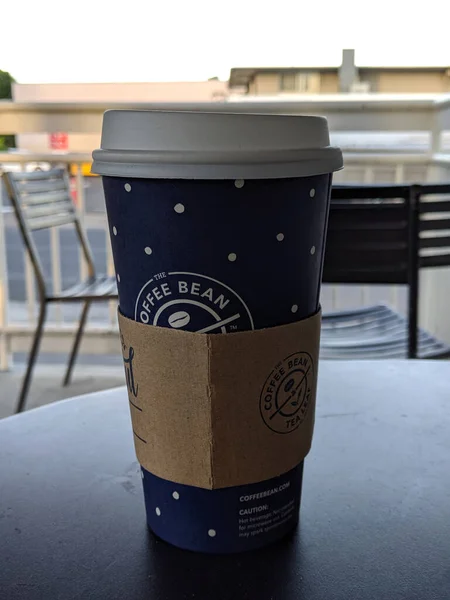 火奴鲁鲁 2019年11月2日 在纸杯中喝大杯咖啡 纸杯上盖着塑料 咖啡豆的硬纸板热包在店外的桌子上 — 图库照片