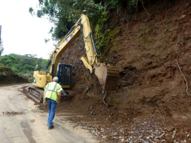 Hawaii - 17 Nisan 2014: CAT Machine, Hawaii, Big Island 'da denetlenirken Waipio Vadisi' ne kadar toprak kazdı.