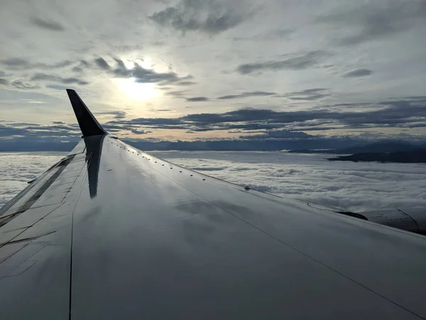 飛行機の翼は 日の出の間 雲に覆われたワシントン州シアトル市上空を飛ぶ — ストック写真