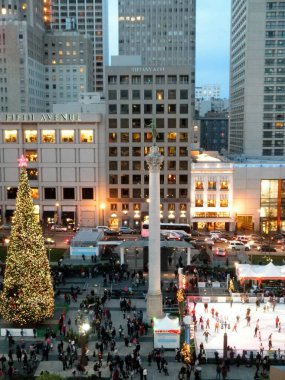 San Francisco - December 24, 2010: Bird-eye view of Christmas Tree, statue, and Holiday Ice Rink filled with people In Union Square with Sak Fifth Avenue, Tiffiany & Co., and Levi's Store in background.