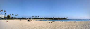 Honolulu - June 4, 2009:  Ala Moana Beach with people hanging out and swimming in the water on a beautiful day.  Panoramic
