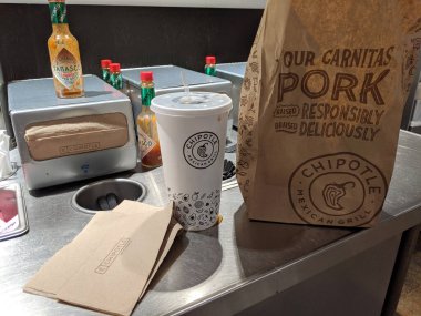 LA, California, ABD - 15 Ekim 2019: Chipotle Mexico Grill yiyecek poşeti ve sos tezgahında içki. 1600 'den fazla yere sahip olan Chipotle' nin 2013 yılında net geliri 327.4 milyon ABD doları ve 45 binden fazla çalışanı vardı..