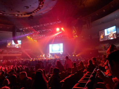 Honolulu - March 24, 2018: Brothers Osborne sings on stage with band playing at the Neal S. Blaisdell Center in red spotlights. clipart