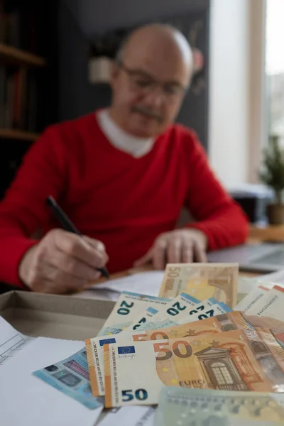 Senior man with eyeglasses counting money from retirement and control finance — стоковое фото