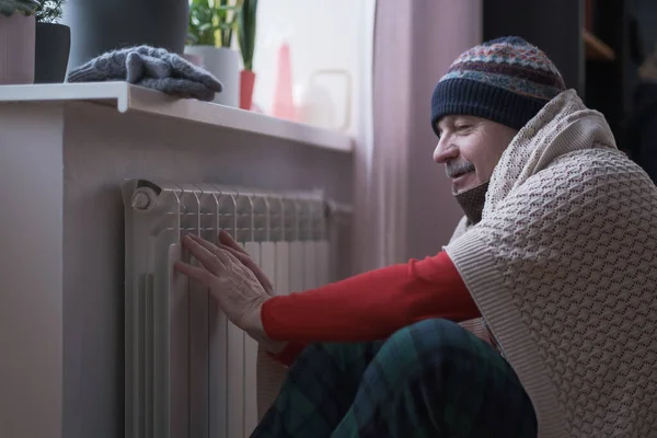 家の暖房のトラブルで寒さを感じる男 ロイヤリティフリーのストック画像