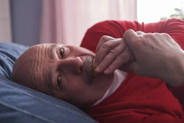 Ανώτερος καυκάσιος άνθρωπος τρώει κέικ κρύβεται από όλους — Φωτογραφία Αρχείου