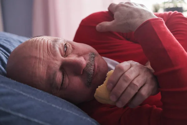 Hombre caucásico mayor comiendo pastel escondido de todo el mundo —  Fotos de Stock