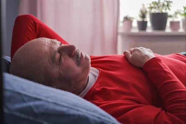 Senior man sover har söt dröm på sängen i sovrummet på morgonen — Stockfoto