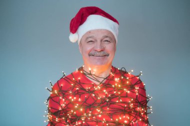 Kırmızı Noel şapkalı son sınıf öğrencisi. Çelenge sarılmış..