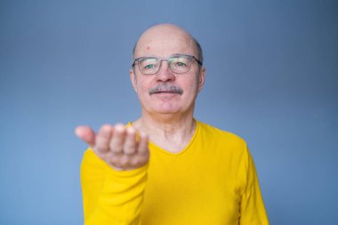 Kıdemli adam avucunda bir şey gösteriyor..