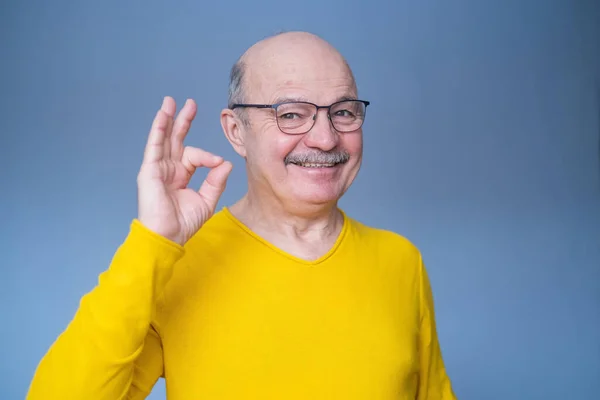 Gut aussehender Mann mittleren Alters lächelt positiv und tut ok Zeichen mit Hand und Fingern. — Stockfoto