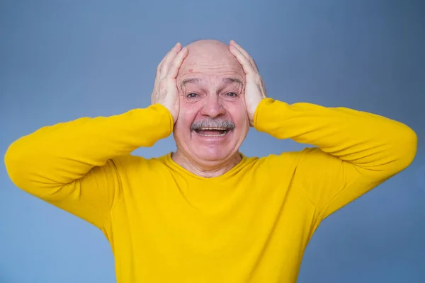 Hombre mayor cubriéndose las orejas con palmas levantadas con terrible dolor de cabeza. —  Fotos de Stock