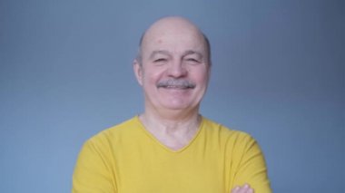 Kıdemli İspanyol adam kameraya gülümsüyor..