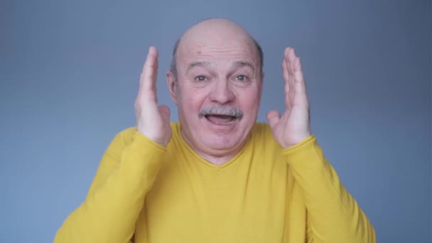Plešatý starší muž je šokován překvapeným výrazem a vzrušenou tváří. — Stock video