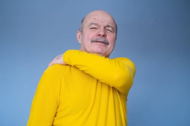 Boynu ve omzu ağrıyan yaşlı İspanyol bir adam.