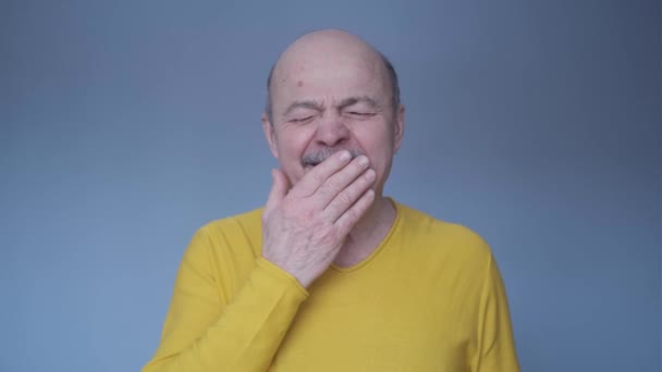 Uomo anziano annoiato sbadigliando stanco bocca di copertura con la mano — Video Stock