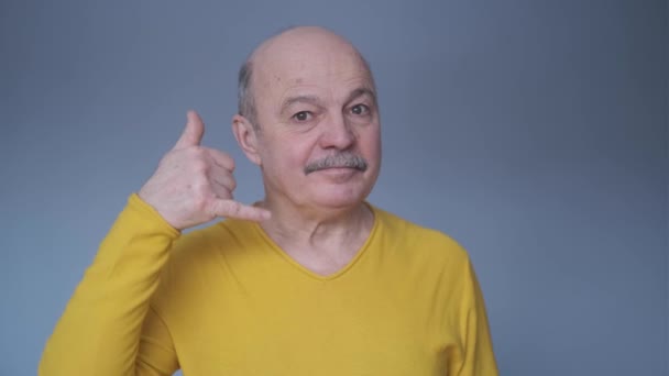 Senior Spaanse man show zicht bel me met vingers — Stockvideo