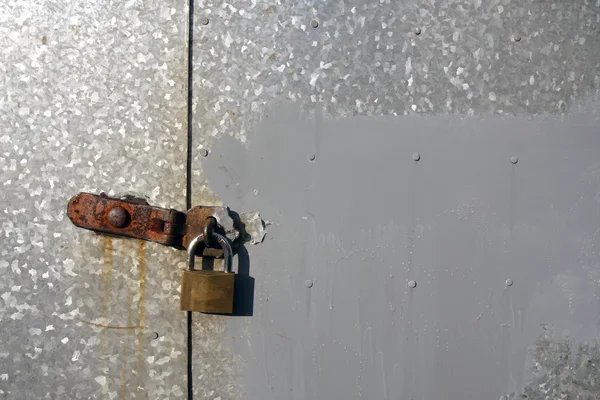 Steel doors locked with a rusty padlock — Stock Photo, Image