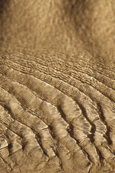 Вода кружится над песчаным пляжем — стоковое фото