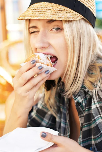 Young woman eats muffin — Stock Photo, Image