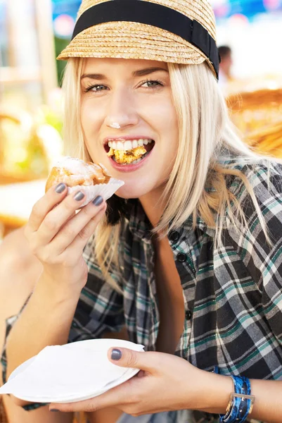 Young woman eats muffin Royalty Free Stock Images