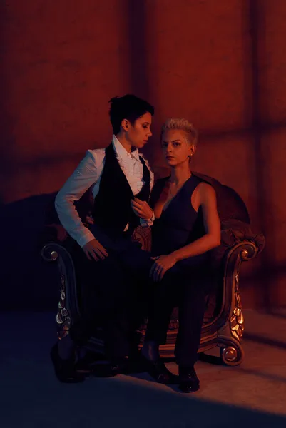 Due lesbiche con sguardo serio in vecchia poltrona — Foto Stock