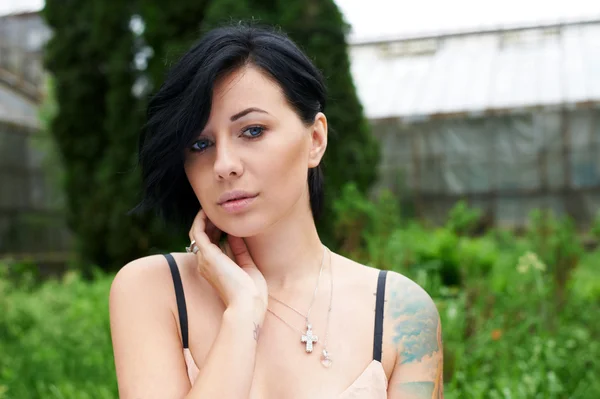 Bonita chica de pelo negro con tatuaje en el jardín —  Fotos de Stock