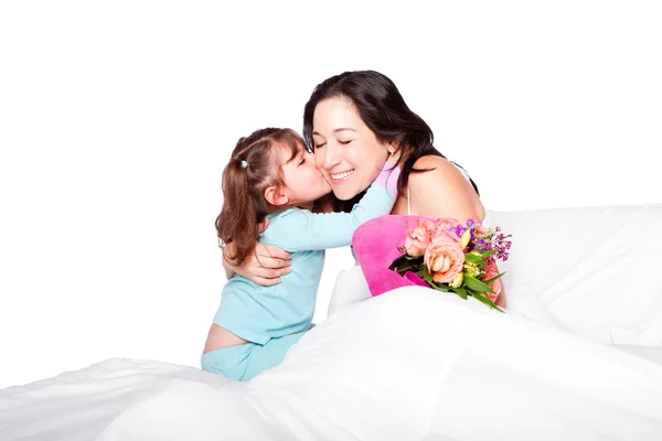 Niño da flores y beso a mamá en la cama — Foto de Stock