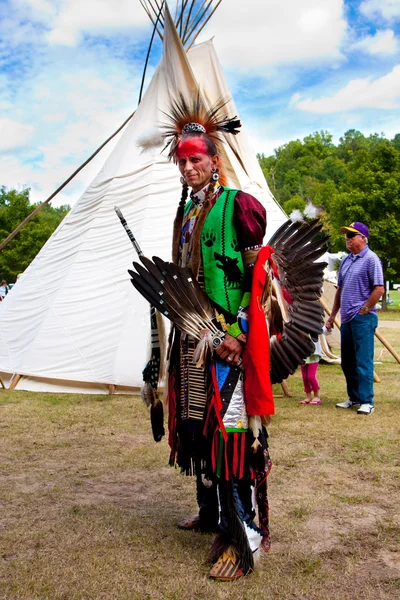 Native American Indian warrior in front of Tipi