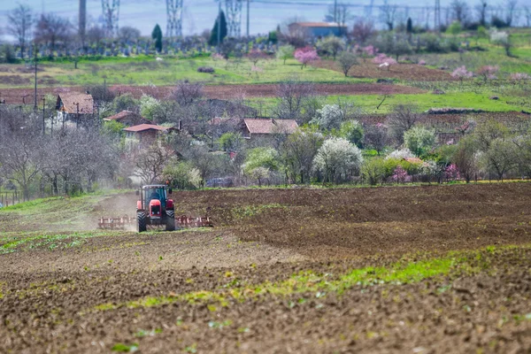 Zbrusu nový červený traktor na poli pracuje na zemi — Stock fotografie