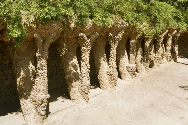 Twisting rock pillars with green plants above inside famous Barcelona's landmark Park Guell — Stock Photo, Image