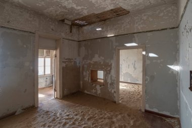 Kolmanskop kasabası Namibya 'da kumla kaplı terk edilmiş bir binanın içinde.