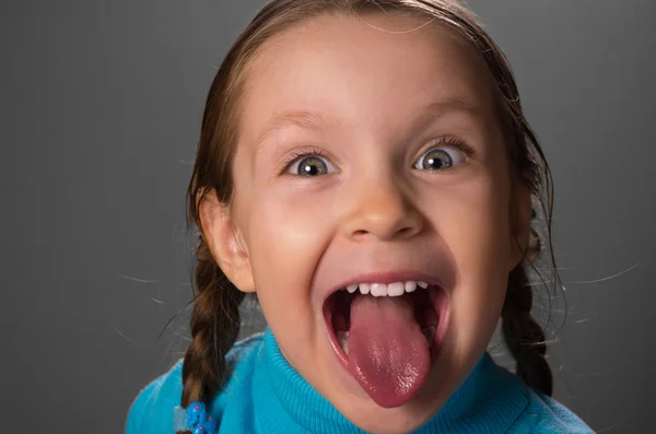 小さな女の子の舌を示す. ロイヤリティフリーのストック画像