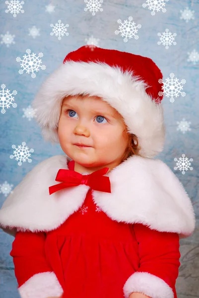 Bebê bonito em chapéu de santa com flocos de neve — Fotografia de Stock