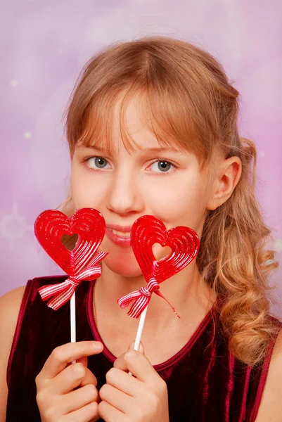 Chica joven con dos piruletas en forma de corazón —  Fotos de Stock